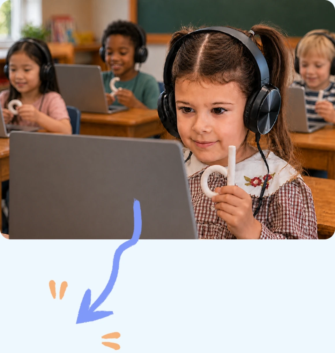 Children at their desks holding clay letters they shaped while working on laptops