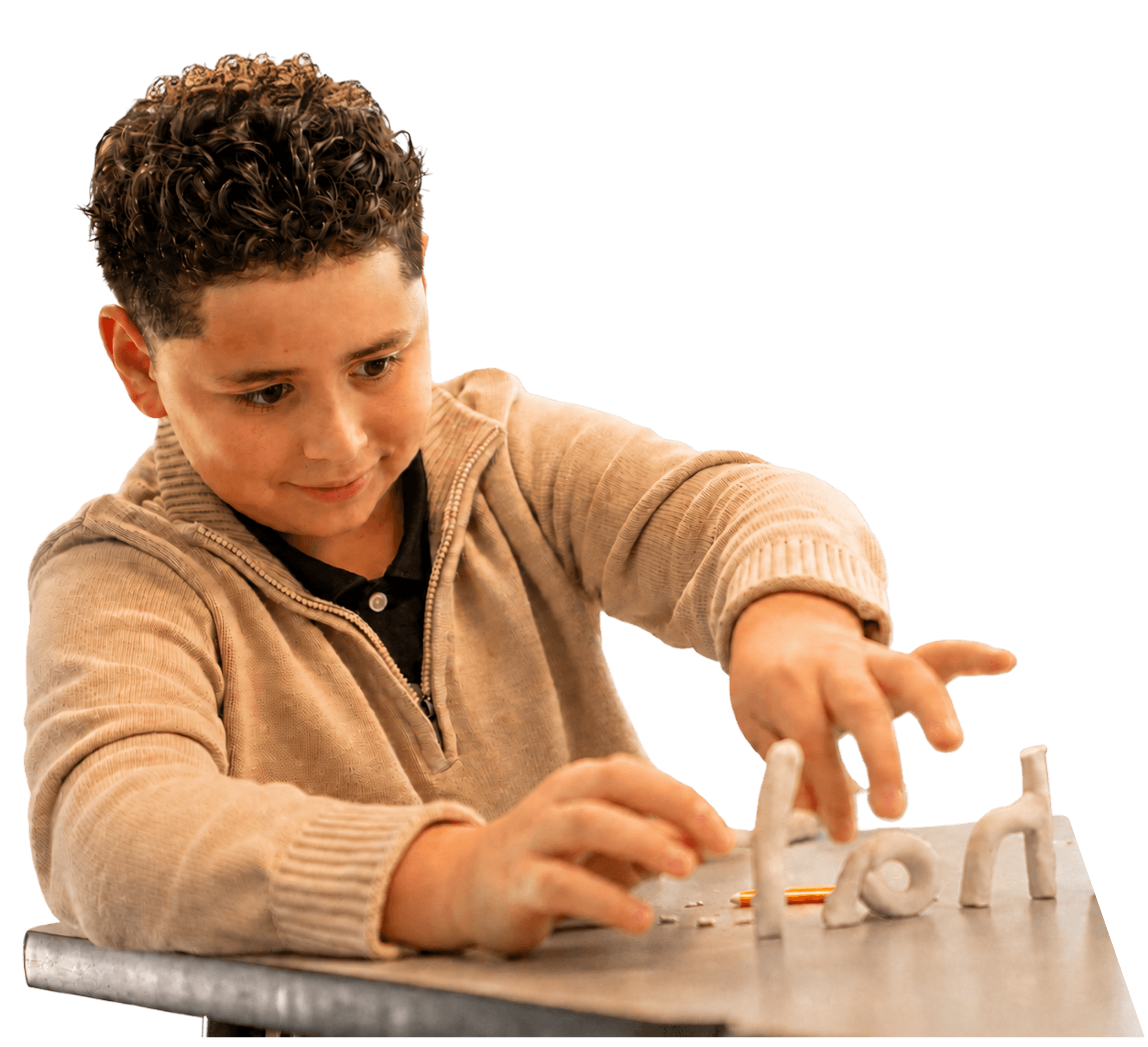 A child placing clay letters on a desk to build a word